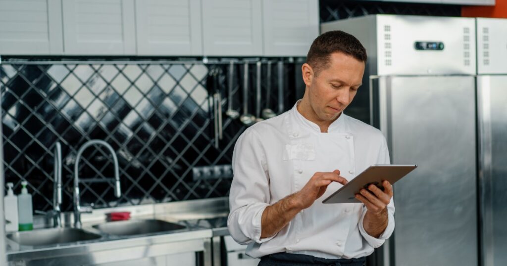 professional chef using tablet computer for menus