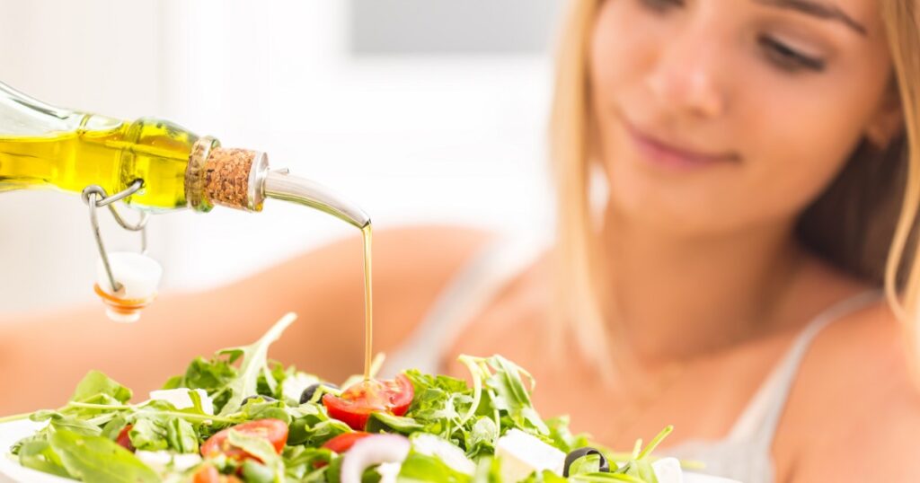 woman seasoning a salad